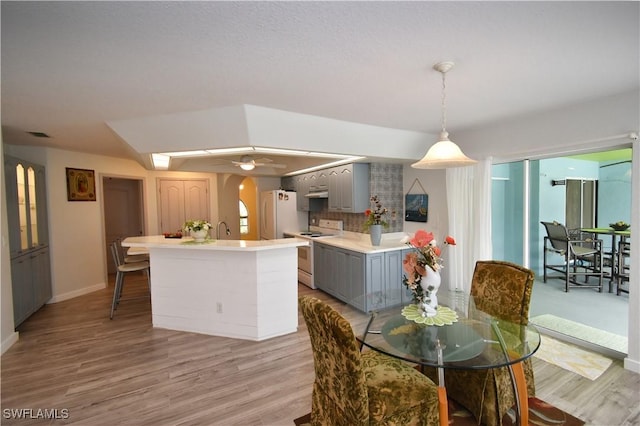 dining room with visible vents, light wood-type flooring, a ceiling fan, and baseboards