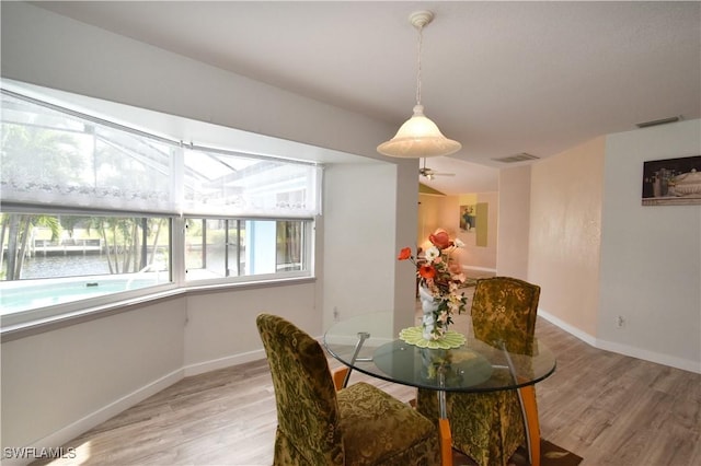 dining area featuring light wood finished floors, visible vents, and baseboards