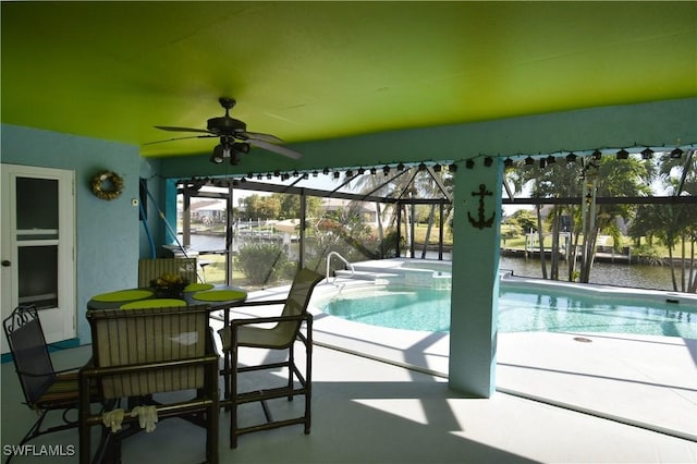 view of pool featuring a pool with connected hot tub, a water view, a patio area, ceiling fan, and a lanai