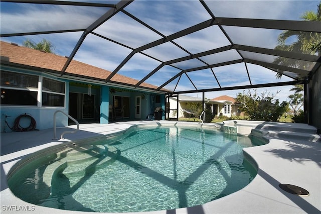 view of swimming pool with glass enclosure, a pool with connected hot tub, and a patio area