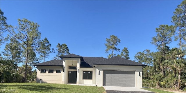 prairie-style home with driveway, a front lawn, an attached garage, and stucco siding