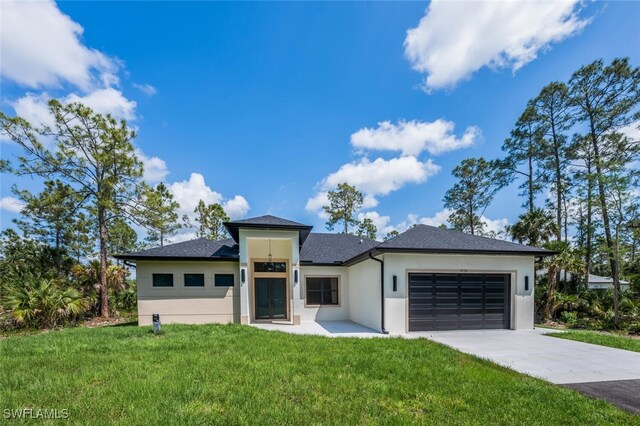 1929 14th Ave NE, Naples, FL 34120 - prairie-style home with a shingled roof, a garage, stucco siding, a front yard, and concrete driveway