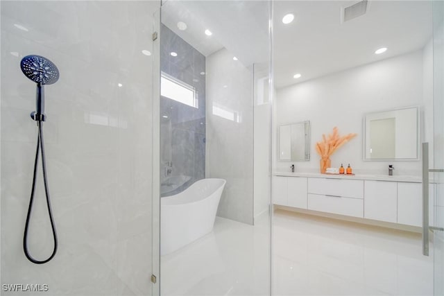 149 SE 21st St, Cape Coral, FL 33990 - bathroom featuring visible vents, double vanity, a freestanding tub, recessed lighting, and a stall shower