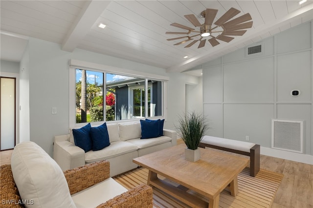 living room featuring visible vents, a decorative wall, lofted ceiling with beams, light wood-style floors, and wood ceiling