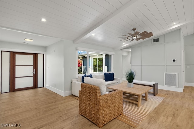 living room featuring light wood-style floors, visible vents, lofted ceiling with beams, and baseboards