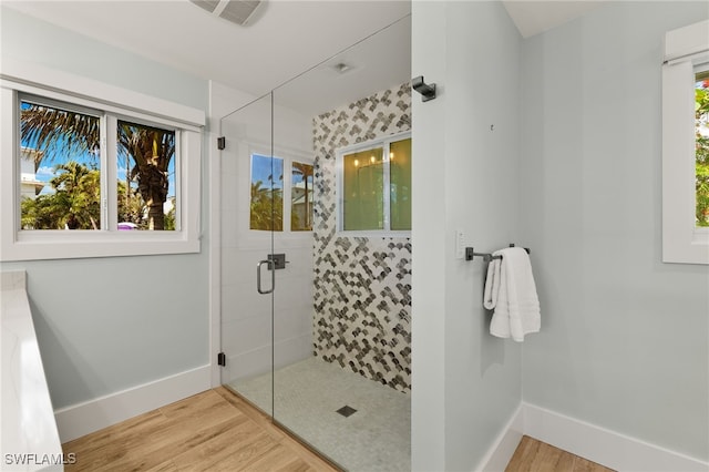 full bath featuring visible vents, a shower stall, baseboards, and wood finished floors