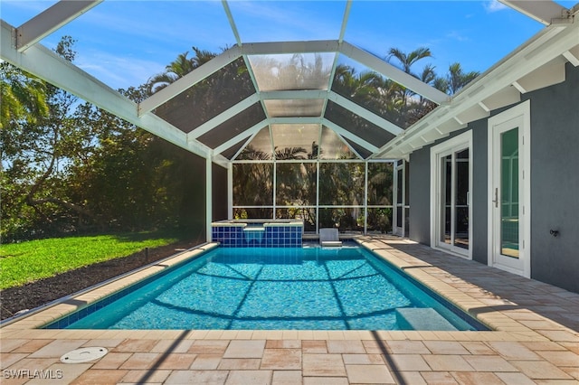 outdoor pool with a patio, glass enclosure, and a hot tub