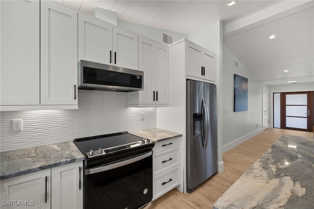 kitchen featuring visible vents, white cabinets, decorative backsplash, vaulted ceiling, and stainless steel appliances