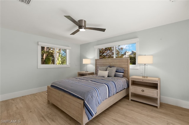 bedroom featuring visible vents, ceiling fan, baseboards, and wood finished floors