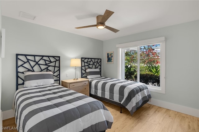 bedroom featuring light wood-style floors, ceiling fan, and baseboards