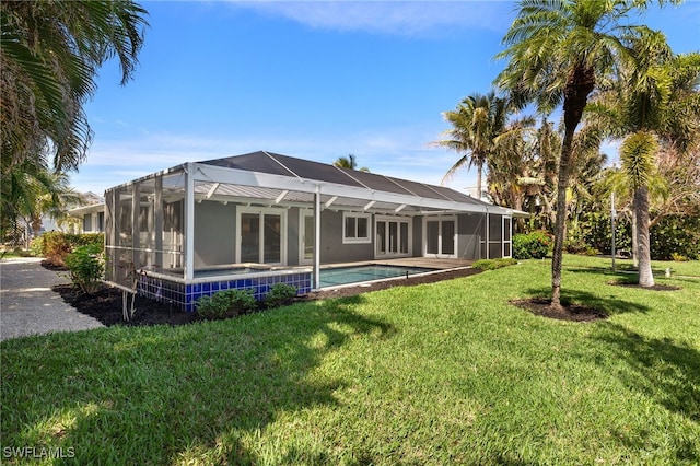 rear view of property featuring a yard, glass enclosure, and an outdoor pool