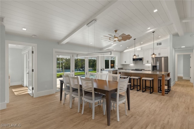 dining space with visible vents, baseboards, light wood-style flooring, vaulted ceiling with beams, and french doors