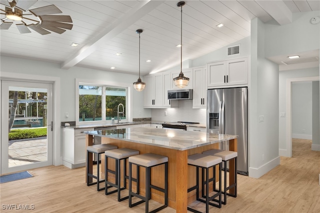 kitchen with tasteful backsplash, visible vents, a center island, stainless steel appliances, and a sink