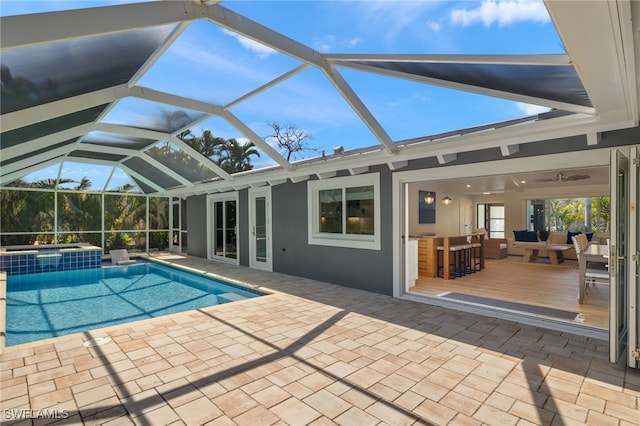 view of swimming pool with outdoor dry bar, a patio, a lanai, and a pool with connected hot tub