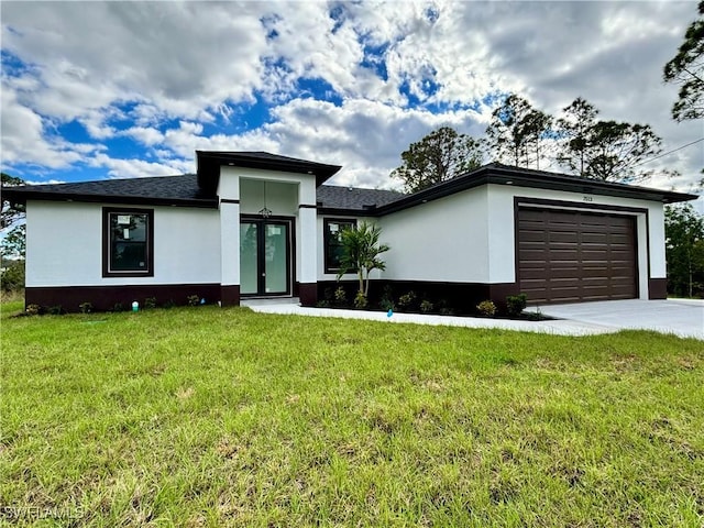 prairie-style home with an attached garage, driveway, a front lawn, and stucco siding