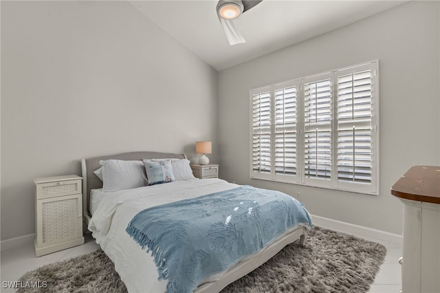 bedroom featuring lofted ceiling and baseboards