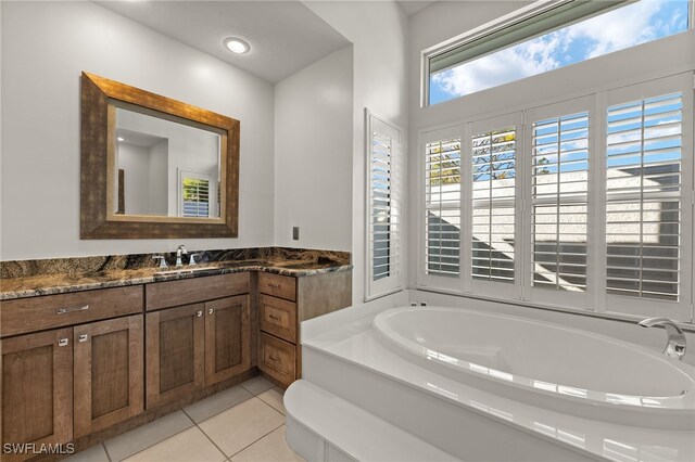 bathroom with recessed lighting, a garden tub, vanity, and tile patterned floors