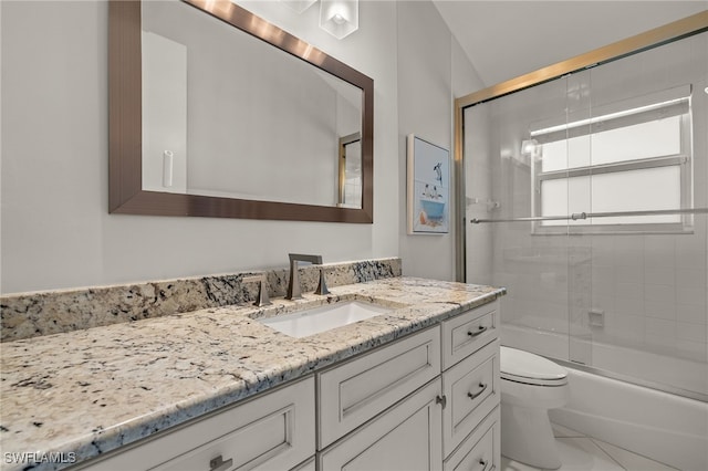 full bath featuring combined bath / shower with glass door, tile patterned flooring, vanity, and toilet