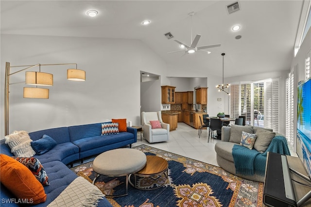 living room featuring light tile patterned floors, high vaulted ceiling, ceiling fan with notable chandelier, and visible vents