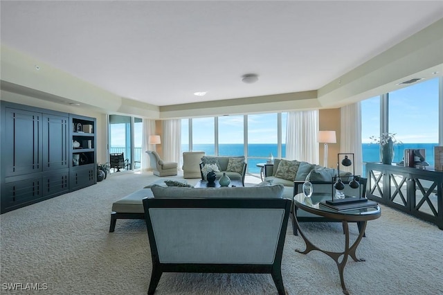 living room featuring visible vents, a water view, and carpet flooring