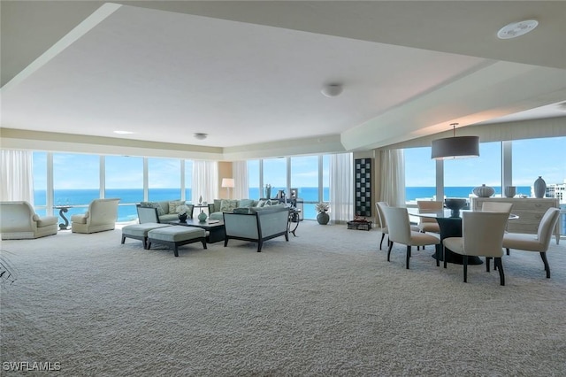 living room featuring plenty of natural light, carpet, and a water view