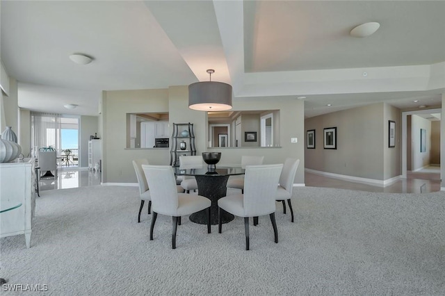 carpeted dining room featuring baseboards