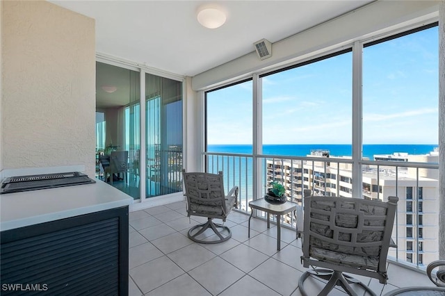 sunroom / solarium with visible vents and a water view