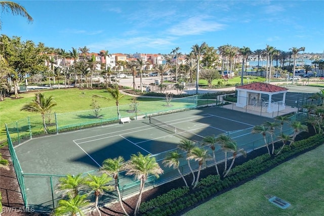 view of sport court with a yard, fence, and a residential view