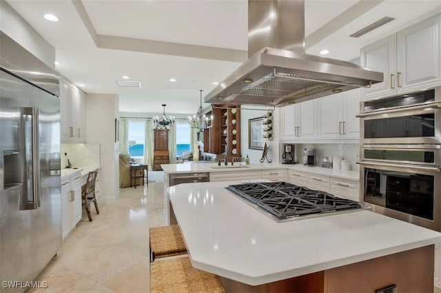 970 Cape Marco Dr Unit 1107, Marco Island, FL 34145 - kitchen with visible vents, white cabinetry, appliances with stainless steel finishes, backsplash, and island exhaust hood