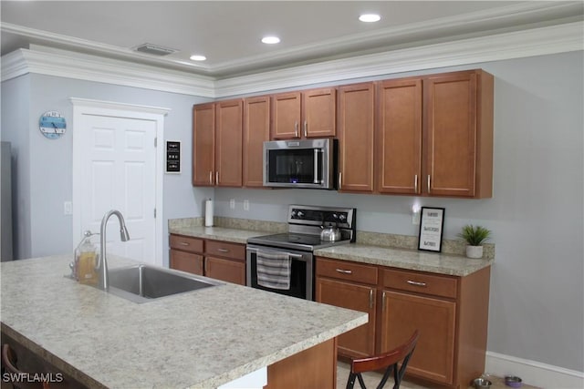 kitchen featuring an island with sink, appliances with stainless steel finishes, brown cabinets, light countertops, and a sink