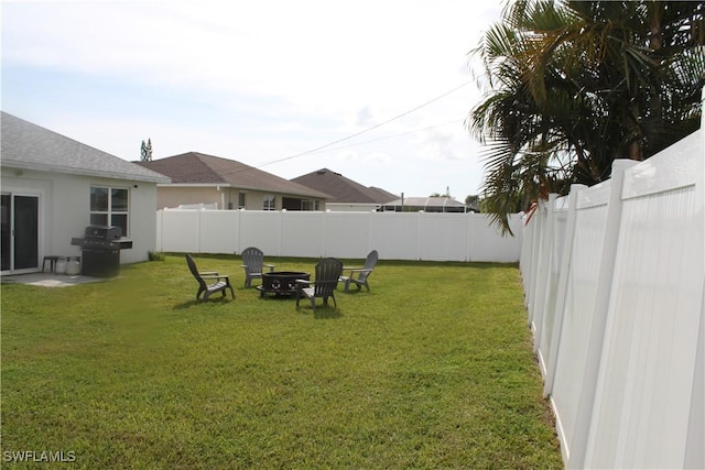 view of yard with a fenced backyard and a fire pit