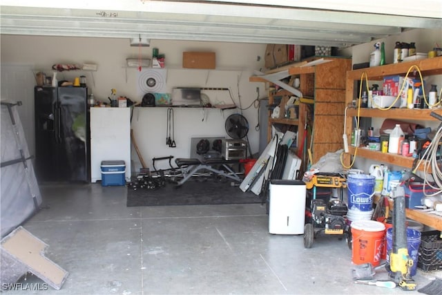 garage with a workshop area and black fridge