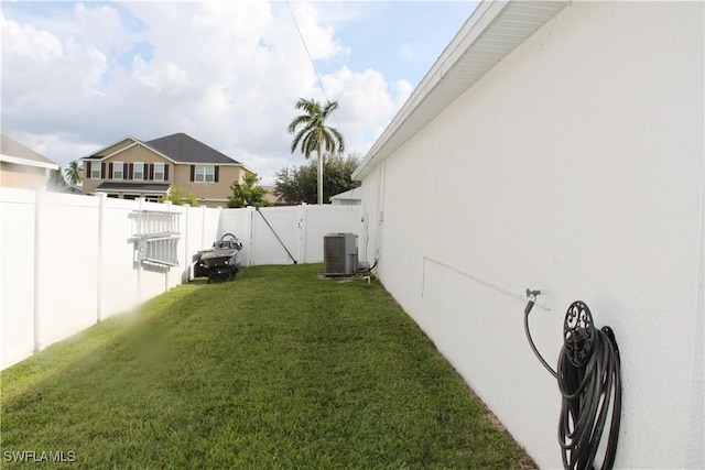 view of yard with a fenced backyard and central AC unit