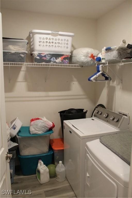 laundry area featuring wood finished floors, laundry area, and separate washer and dryer