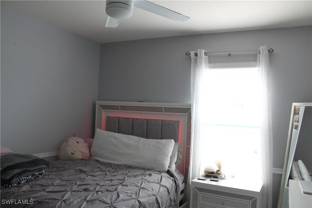 bedroom with ceiling fan and multiple windows