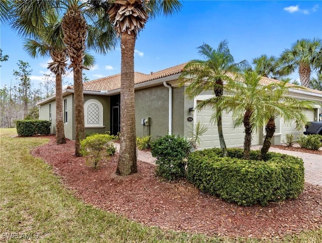 view of front facade with a garage, a tiled roof, decorative driveway, and stucco siding