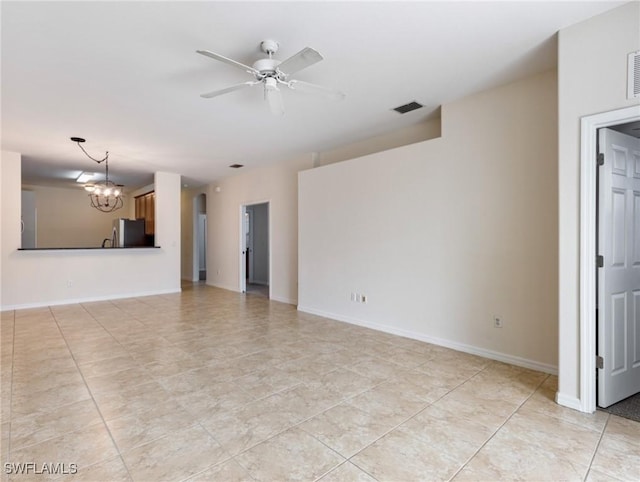 spare room featuring ceiling fan with notable chandelier, light tile patterned floors, visible vents, and baseboards