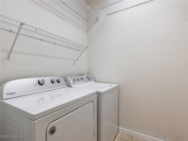 washroom with laundry area, baseboards, and washer and clothes dryer