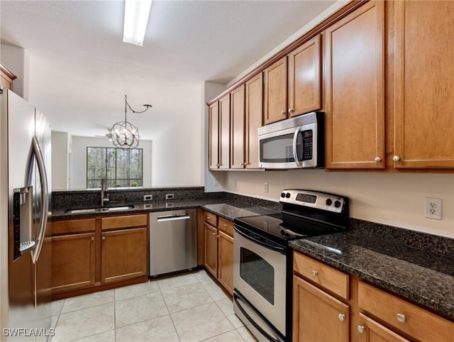 kitchen featuring stainless steel appliances, brown cabinetry, and a sink