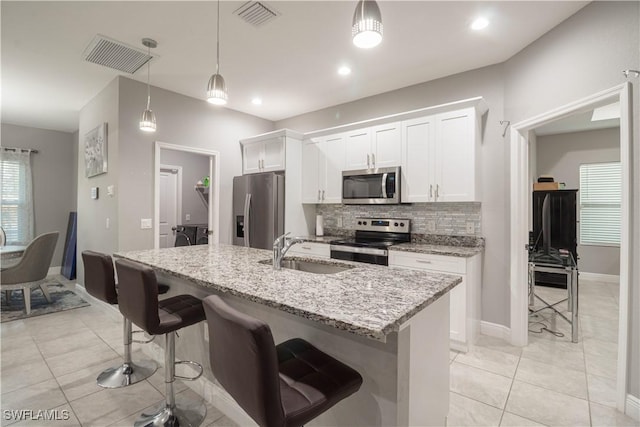 kitchen featuring visible vents, appliances with stainless steel finishes, white cabinets, and a sink