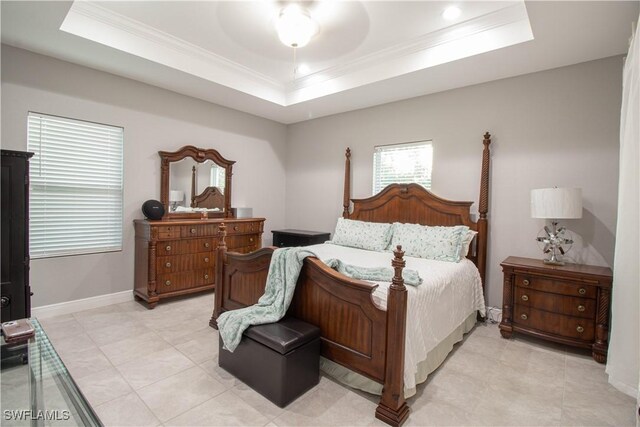 bedroom featuring baseboards, a tray ceiling, and crown molding