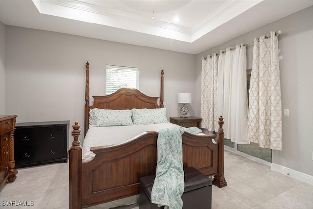 bedroom with baseboards, a tray ceiling, and crown molding