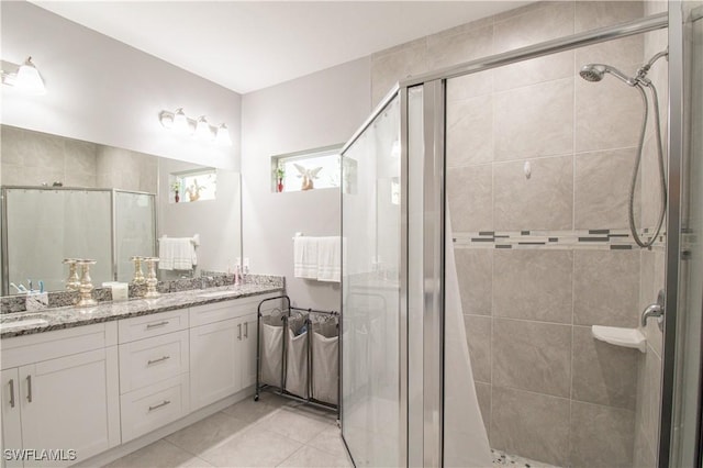 bathroom featuring a stall shower, tile patterned flooring, a sink, and double vanity