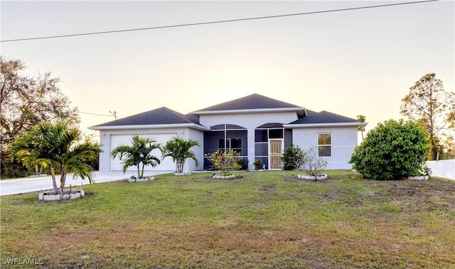 view of front facade featuring a garage, a front yard, concrete driveway, and stucco siding