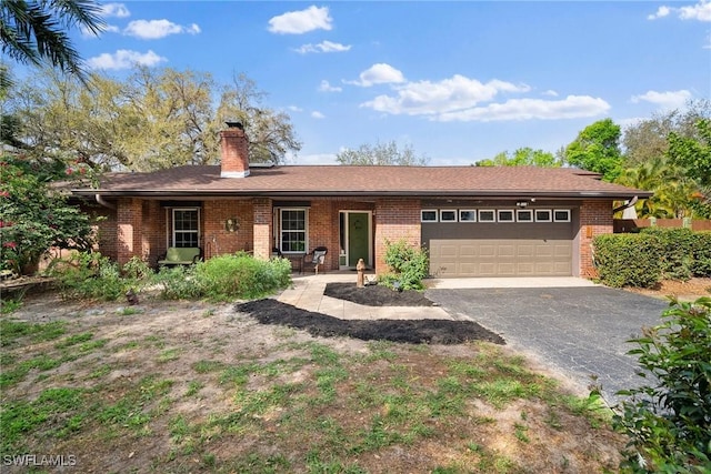 ranch-style house with brick siding, driveway, a chimney, and an attached garage