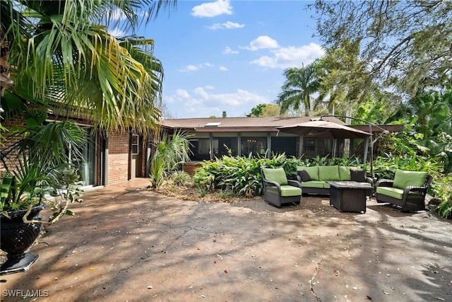 rear view of property featuring an outdoor hangout area, a patio, and brick siding