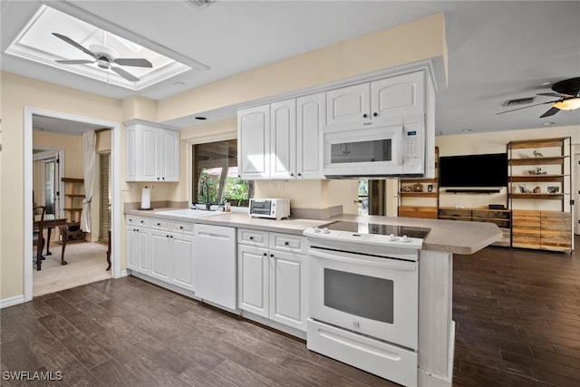 kitchen featuring a skylight, white cabinetry, a sink, ceiling fan, and white appliances