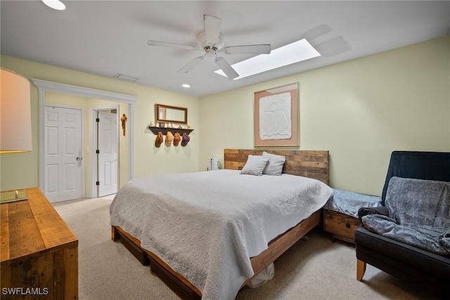 bedroom featuring a skylight, carpet, visible vents, and ceiling fan