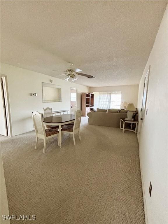 carpeted dining room featuring a textured ceiling and ceiling fan