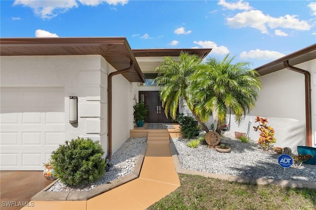 exterior space with an attached garage and stucco siding